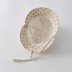 Close-up of baby sun hat with polka dot print, mesh lining and adjustable chin strap