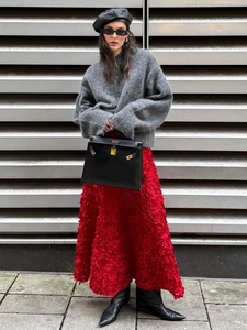 Detailed view of red 3D floral texture on a luxury midi skirt with an elegant finish