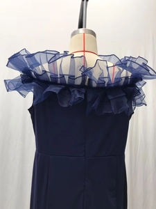 Detailansicht des gerüschten Off-Shoulder-Ausschnitts an einem dunkelblauen Strickkleid