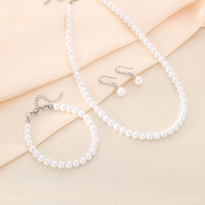 Elegant set of 6mm white pearl necklace bracelet and earrings on beige silk fabric