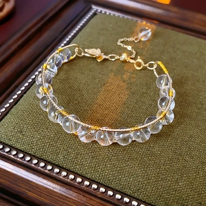 Detail of tiger eye and crystal beaded bracelet with gold wire wrap and adjustable chain