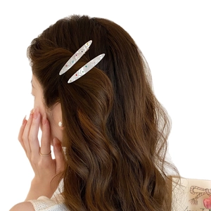 Barrettes élégantes en acrylique blanc avec cristaux colorés portées par un modèle