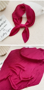 Detailed view of rose red pleated silk scarf showing fine accordion texture and fabric