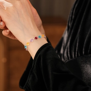 Detail of colorful oval-cut zircon bracelet with silver-tone prong settings on wrist