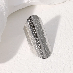 Men's wide stainless steel ring with unique hammered texture on white stone background