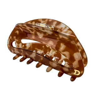 Detailansicht einer großen Haarklammer mit Schildpattmuster, goldenem D und Greifzähnen