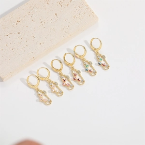 Detailaufnahme goldener Evil Eye Ohrringe mit farbenfrohen Emaille Pillen Anhängern