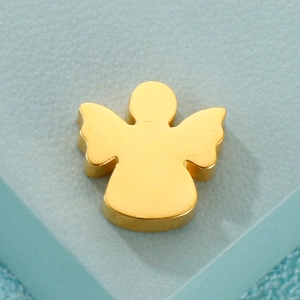 Polished golden angel wing locket necklace pendant on a light blue textured surface