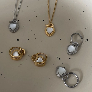 Detail of heart lock necklaces and earrings with cat eye stones in gold and silver