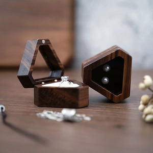 Macro view of two hexagonal wooden jewelry boxes for rings and necklaces on a desk