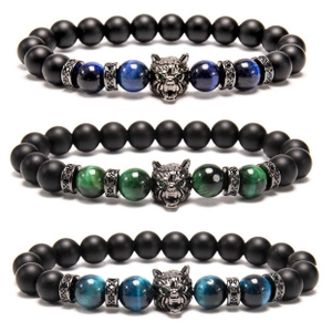 Detail of beaded men's bracelets with matte black lava stone and metallic wolf head charm