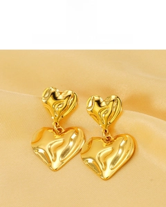Détail de boucles d'oreilles double cœur plaqué or 18K avec texture martelée sur soie