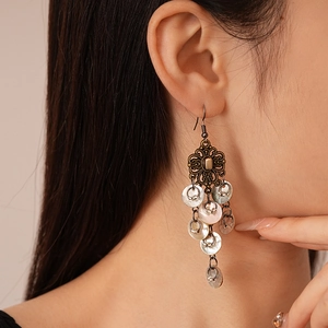 Vintage style Chinese knot earrings with shell charms worn by a female model