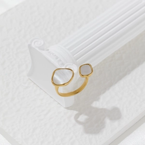 Detailed macro shot of gold open ring with irregular shell inlays on a Roman column