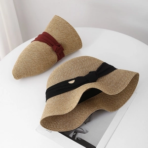 Chapeaux de paille élégants à large bord avec rubans colorés sur table blanche