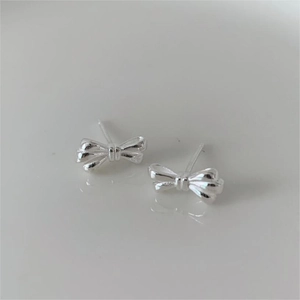 Close-up of minimalist silver bow stud earrings for women with sleek metallic finish
