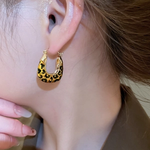 Close-up of vintage leopard print U-shaped gold earrings worn by a female model