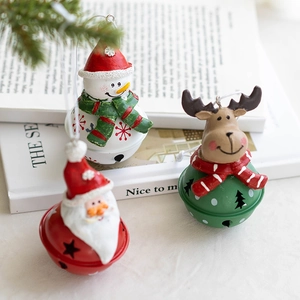 Christmas resin Santa and snowman metal bells hanging on tree branch with warm lighting