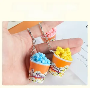 Detailed view of colorful popcorn bucket keychains in blue, yellow, and pink colors
