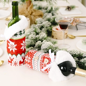 Close-up of knitted Christmas wine bottle covers with snowflakes and faux fur trim