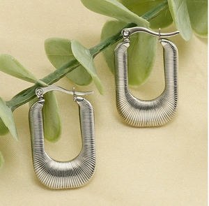 Detail of silver U-shaped earrings with radial ridge texture and lever back closure