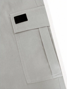 Detailed close-up of light grey cargo pants pocket featuring durable twill fabric stitching
