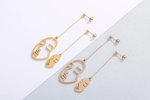 Détails de boucles d'oreilles abstraites en or et or rose avec de longues chaînes