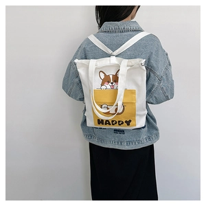Detail of white canvas bag with cute Corgi print and yellow Happy pocket as backpack