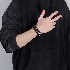 Men's braided black leather bracelet with embossed silver steel accents on wrist