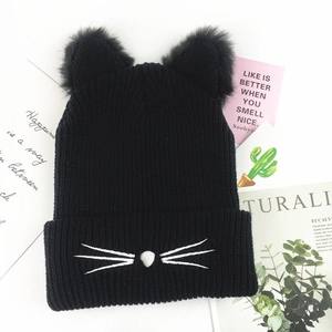 Detail of black knit beanie with plush cat ears and white embroidered whiskers