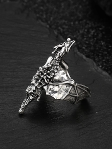 Macro shot of silver dragon ring wings and scales detail on black stone background