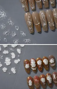 Nahaufnahme von 5D geprägten weißen Blumen-Nagelstickern mit 3D-Perlen und Goldakzenten