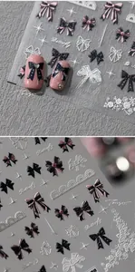 Detail of 5D embossed nail stickers featuring pink and black bowknots with lace patterns