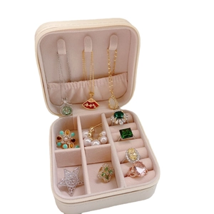 Portable cream jewelry box with necklace hooks and ring slots for travel storage