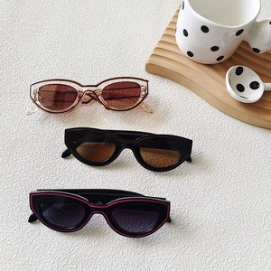Three pairs of vintage cat-eye sunglasses in brown, black, and red-trimmed colorways