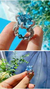 Macro view of blue Asscher cut gemstone ring with twisted diamond pavé band