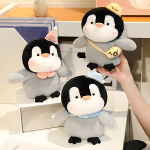Three plush penguin dolls with cute colorful hats and accessories on a white stand