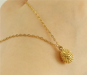 Macro detail of 18k gold plated durian fruit pendant with textured 3D relief on skin