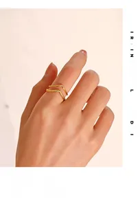 Dettaglio di un anello a doppia V in oro dal design minimalista con finitura testurizzata