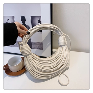 Close-up of a white knotted design shoulder bag with layered artistic rope textures