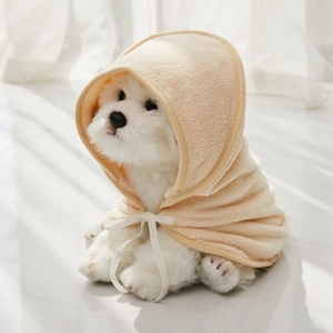 Close-up of thick cream-colored microfiber pet bathrobe with hood and white tie strap detail