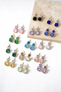 Detailed macro of multi-colored square crystal earrings with gold-plated metal settings