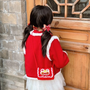 Child in red festive coat with handmade knitted lion dance crossbody bag for New Year