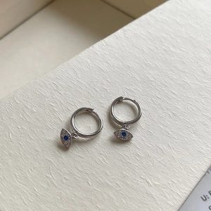 Macro view of S925 sterling silver evil eye hoop earrings with blue and white crystals