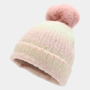 Detail of pink tie-dye knit beanie featuring a soft faux fur pompom and gradient texture
