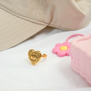 Detailed view of a vintage gold heart ring with ornate lock carving and baroque patterns