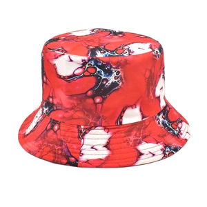 Détail de l'imprimé graffiti artistique rouge, blanc et noir sur un chapeau bob de mode