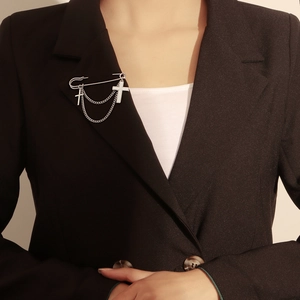 Cross pendant brooch with white shell and silver chain styled on a black blazer