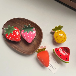 Summer fruit acrylic hair claws including strawberry and pineapple on a wooden tray