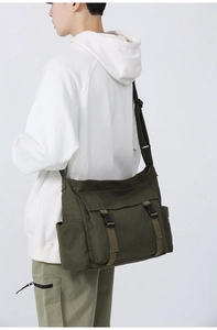 Sac bandoulière en toile vert armée porté par un mannequin montrant la taille